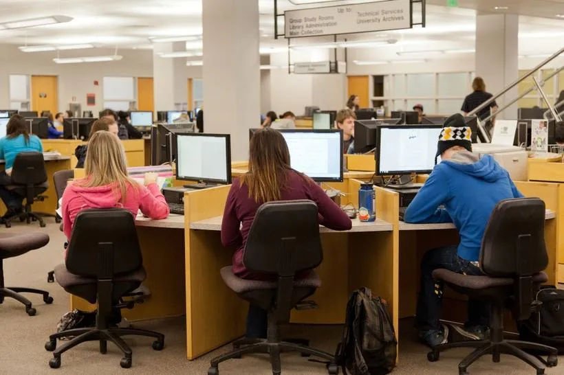 Three students working on computers at the UCCS Library